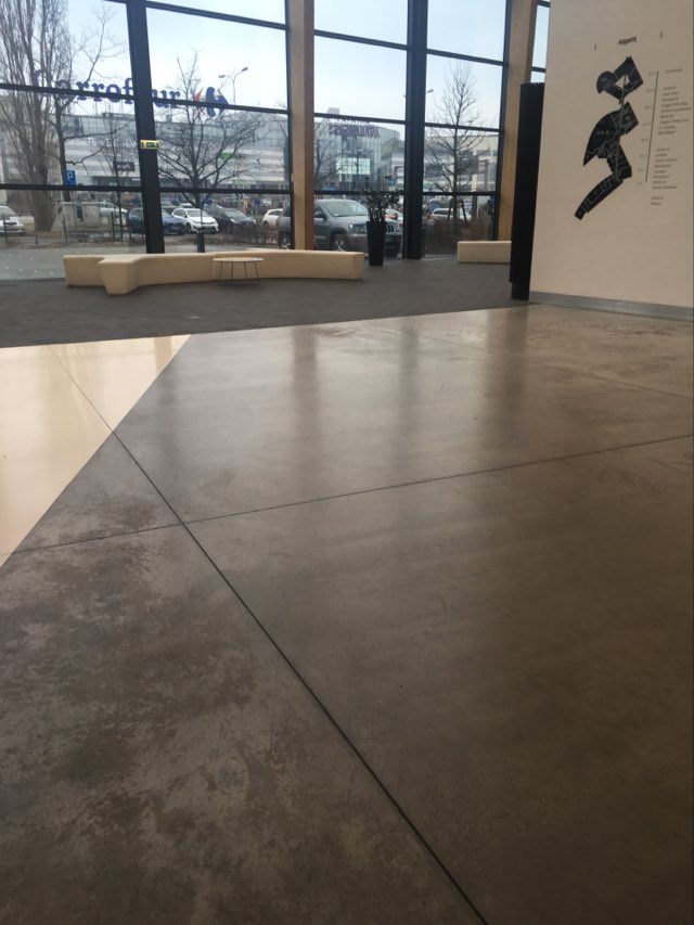 Polished concrete floor with visible signs of wear. If polyurethane varnish was used for concrete, the floor would be less damaged.